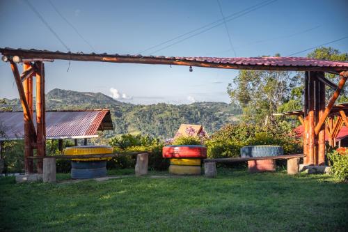 a wooden pergola with a picnic table in a yard at Hotel Cabañas y Glamping Colinas De San Diego in San Agustín