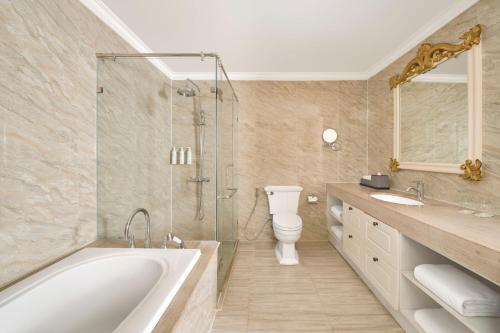 a bathroom with a tub and a toilet and a shower at Nha Trang Marriott Resort & Spa, Hon Tre Island in Nha Trang