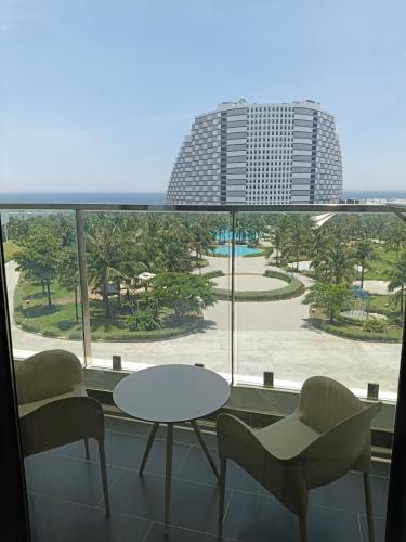 a room with a table and chairs and a view of a building at The Arena Sunrise Cam Ranh in Thôn Hòa Ða