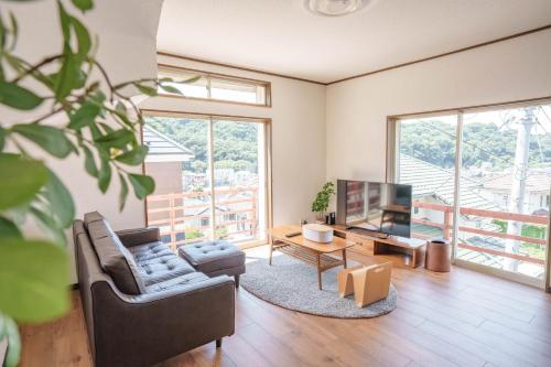 a living room with a couch and a tv at 逗子海岸近くの広さ104平米の一棟貸しNetflixあり in Hayama