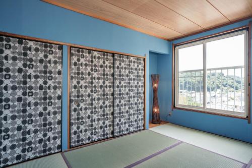 a room with blue walls and a large window at 逗子海岸近くの広さ104平米の一棟貸しNetflixあり in Hayama