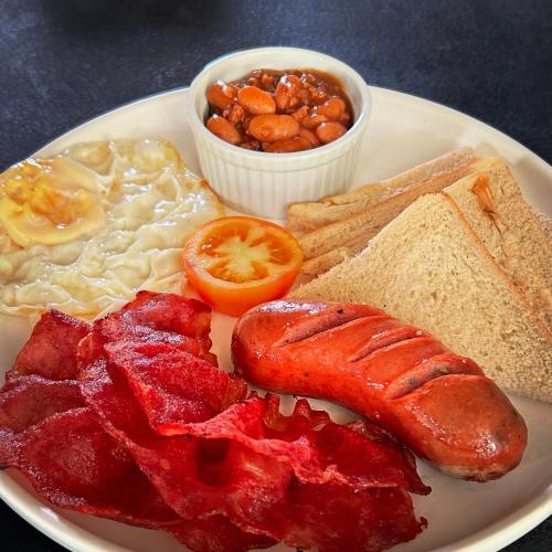 a plate of breakfast food with eggs bacon beans and toast at Luxor Resort in Gasan