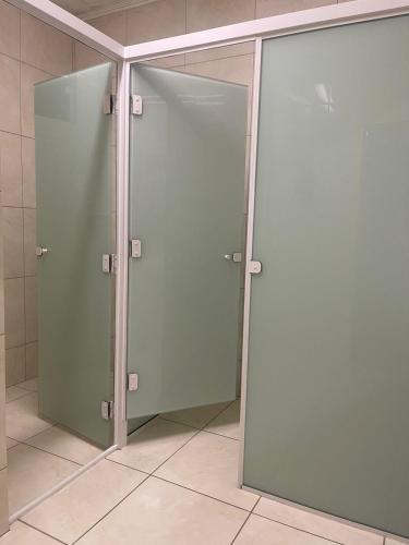 two sliding glass doors in a shower in a bathroom at Hospedagem Dona Ester in Pomerode