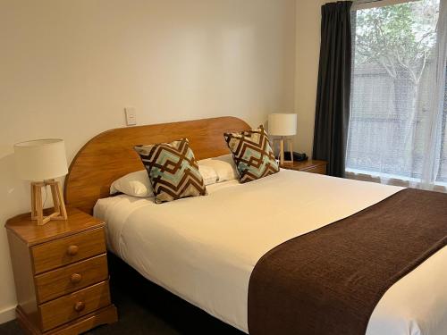 a bedroom with a large bed and a window at Bush Inn Court Motel in Christchurch