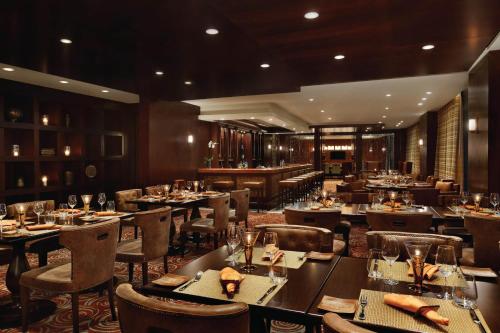 a dining room with tables and chairs in a restaurant at JW Marriott Marquis City Center Doha in Doha