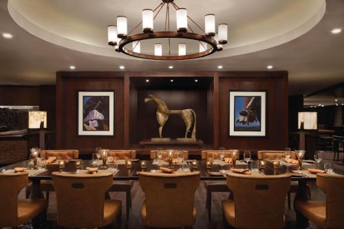 a dining room with a table and a statue of a horse at JW Marriott Marquis City Center Doha in Doha