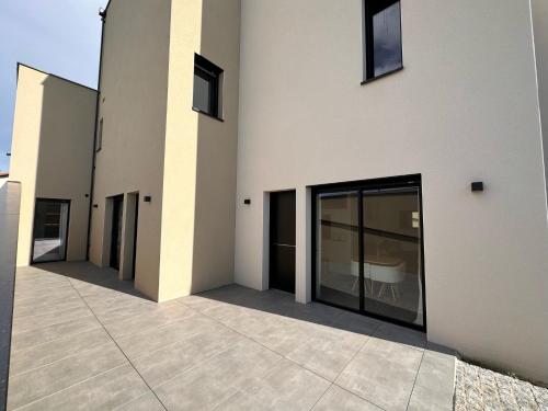 a building with glass doors on the side of it at Appartement ROSE, Aéroport ST EXUPERY, Groupama stadium, Eurexpo, LDLC Arena in Pusignan