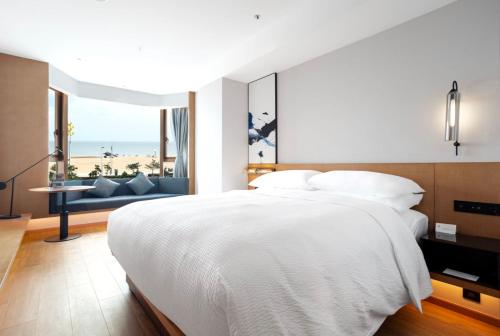 a bedroom with a bed and a view of the beach at Fairfield by Marriott Yantai in Yantai