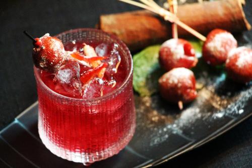 a red drink sitting on top of a plate with apples at The Ritz-Carlton Beijing in Beijing