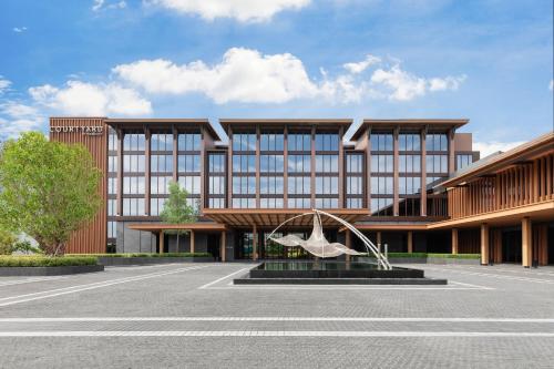a rendering of a building with a sculpture in a parking lot at Courtyard by Marriott Bangkok Suvarnabhumi Airport in Lat Krabang