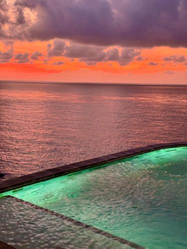a swimming pool with the ocean in the background at Makawi Tuwa in Seraya