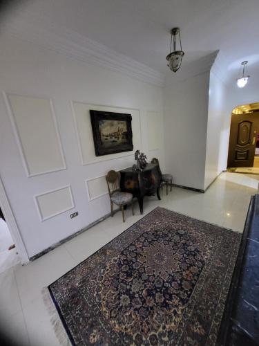 a room with a table and a rug on a wall at شقه فى ميامى بالاسكندريه مطله على البحر in Alexandria