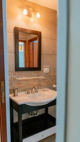 a bathroom with a sink and a mirror at Cerro Pirámide Alojamiento in Caviahue