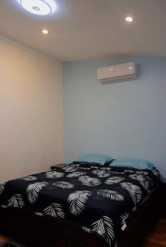 a bedroom with a bed with a black and white blanket at The Loft Nook - 2 bedrooms only in Pusok