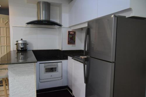 a kitchen with a refrigerator and a stove top oven at The Loft Nook - 2 bedrooms only in Pusok