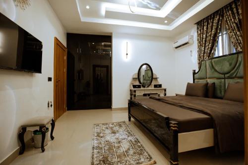 a bedroom with a large bed and a mirror at Elite Luxury 3-bedroom Apartment in Abuja in Abuja