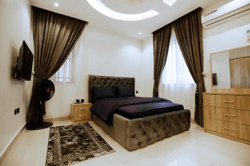a bedroom with a large bed and a dresser at Elite Luxury 3-bedroom Apartment in Abuja in Abuja