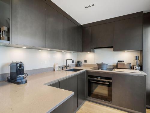 - une cuisine avec des placards brun foncé et un évier dans l'établissement Luxueux Duplex Courchevel 1850, 3 Chambres, près des Pistes, Parking, Services Inclus - FR-1-564-118, à Courchevel