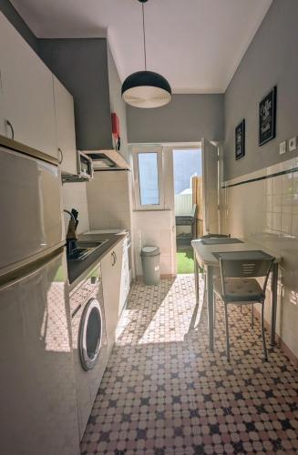 a kitchen with a table and a washing machine at Centro Cidade Holiday in Portimão