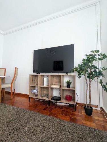 a living room with a flat screen tv on a entertainment center at Centro Cidade Holiday in Portimão