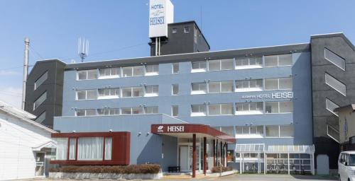a large gray building with a red trim at Business Hotel Heisei in Yonezawa