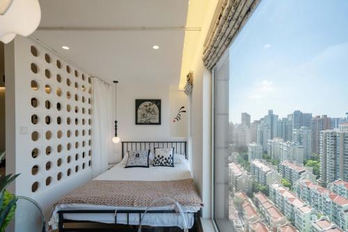 a bedroom with a bed and a large window at Shanghai Yi Du B&B - Near Nanjing West Road commercial district, 350 walk from the Natural History Museum subway in Shanghai