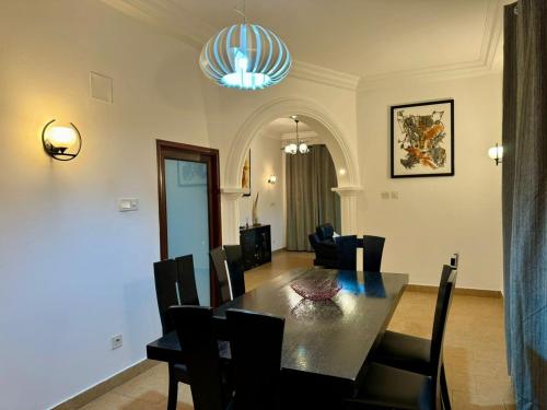 a dining room with a black table and chairs at Villa charden pharell in Pointe-Noire