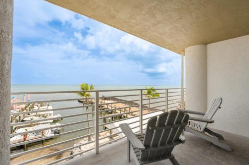 a balcony with two chairs and a view of the beach at Hadley Resort and Marina in Islamorada