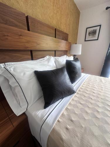 a bedroom with a bed with black and white pillows at Hotel Boutique La Mansión Guadalajara in Guadalajara