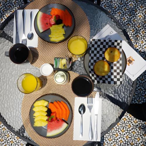 a table with two plates of fruit and orange juice at Hotel Boutique La Mansión Guadalajara in Guadalajara