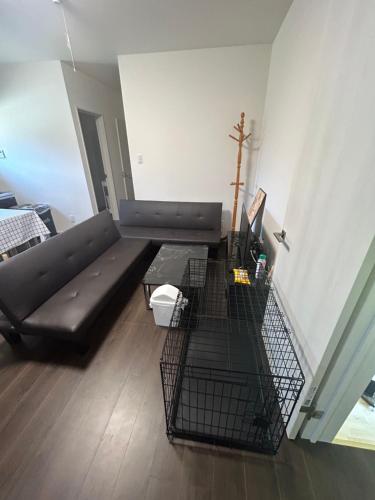 a living room with a black couch and a table at 高島市一棟貸切 Biwa Lake琵琶湖 徒歩0分 大人数でご利用だとお得連泊がお得BBQ自転車無料利用可ペット可 in Takashima