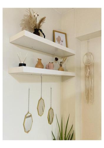a shelf with three pendulum pendulum pendants on a wall at Bohemian Inspired Studio Unit1 at Trees Residences in Manila