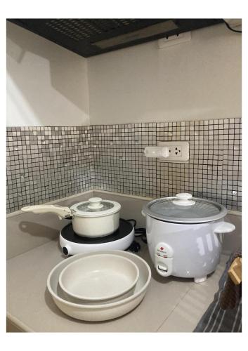 a kitchen counter with two pans and a crock pot at Bohemian Inspired Studio Unit1 at Trees Residences in Manila
