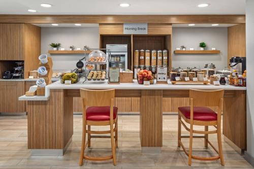 Un mostrador de panadería con dos taburetes en el mostrador. en TownePlace Suites Chicago Lombard, en Lombard