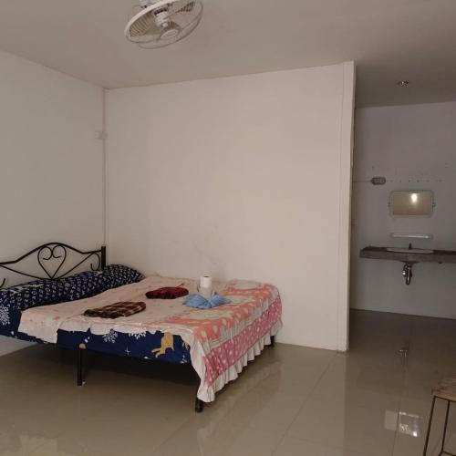 a bedroom with a bed in a white room at Sunny in town hostel in Pai
