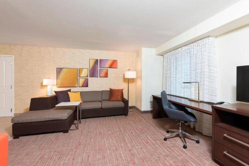 a hotel room with a couch and a desk at Residence Inn by Marriott Milwaukee West in Wauwatosa