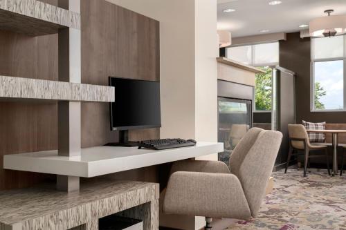 a desk with a computer and a chair in a room at Residence Inn by Marriott Milwaukee West in Wauwatosa