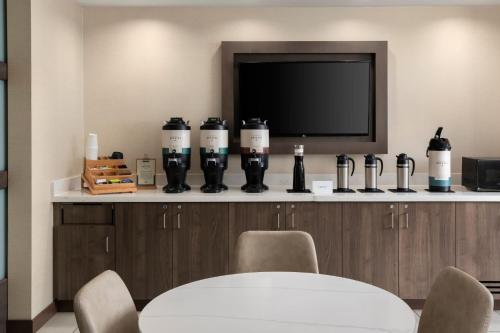 a dining room with a table and a tv at Residence Inn by Marriott Milwaukee West in Wauwatosa