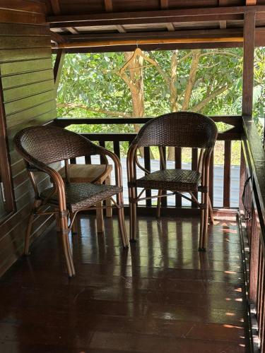 two chairs and a table on a porch at Golden Chenang Village in Pantai Cenang