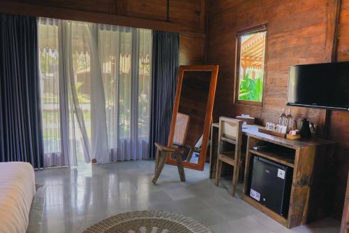 a living room with a television and a mirror at Bhalance Retreat in Padangbai