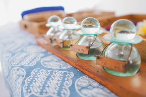 a wooden table with three glass domes on it at Bhalance Retreat in Padangbai