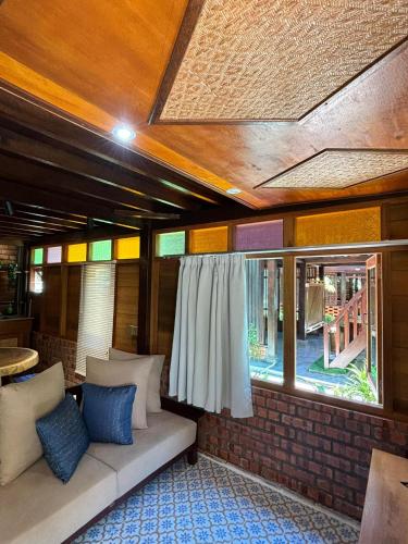 a living room with a couch and a window at Golden Chenang Village in Pantai Cenang