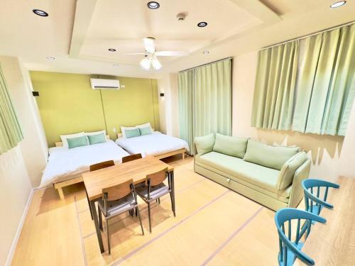 a room with two beds and a table and a couch at 花宿浅草二番 Hanayado Asakusa2 in Tokyo