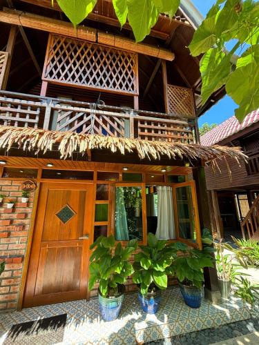 a building with potted plants in front of it at Golden Chenang Village in Pantai Cenang