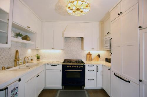 a kitchen with white cabinets and a black stove top oven at La Jolla Beach Villa Gem in San Diego