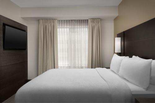 a hotel room with a large bed and a window at Residence Inn Charlotte SouthPark in Charlotte