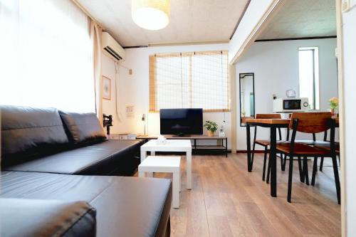 a living room with a couch and a table at 夢の舎代々木 Yumenoya Yoyogi in Tokyo