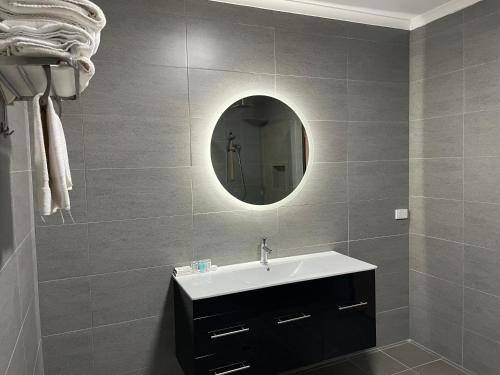 a bathroom with a sink and a mirror at Golden Chain Country Plaza Motel Halls Gap in Halls Gap