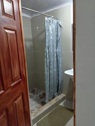 a shower in a bathroom with a glass door at Hostal Sunset Town in Ahuachapán