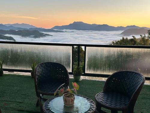 a table and two chairs on a balcony with a view at Mountain View Cabin 1 in Tanay